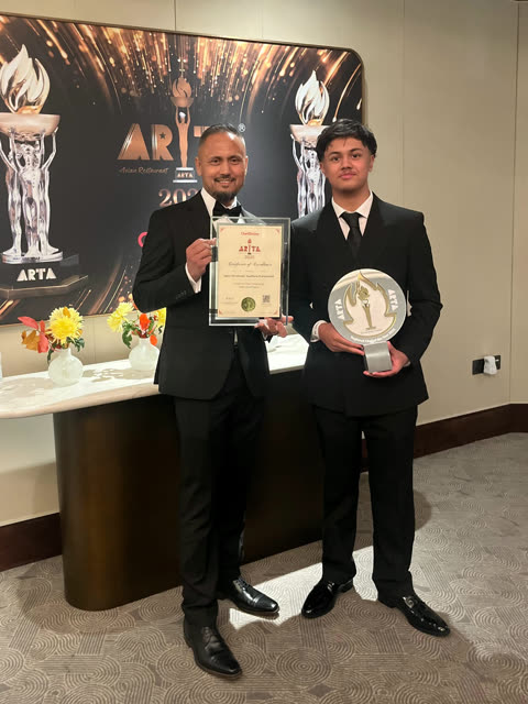 Two Spice Merchants representatives holding an ARTA 2026 trophy and certificate.